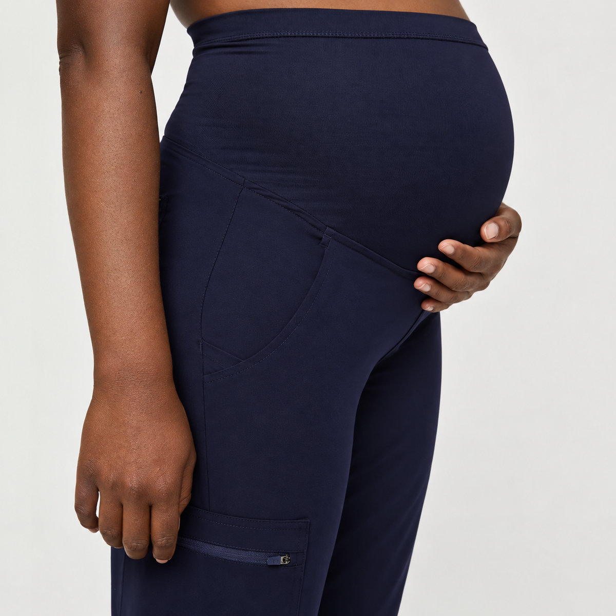 Close-up of navy blue SMSG maternity jogger pants showing 4-way stretch ribbed yoga fabric over-belly support panel and side cargo pocket
