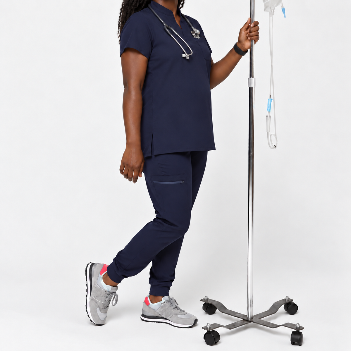 SMSG maternity scrubs complete set in navy blue on pregnant healthcare worker with stethoscope and IV stand in clinical setting